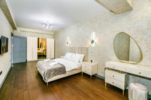 une chambre avec un grand lit et un miroir dans l'établissement Panorama Residence Sea View Apartment by Baku Housing, à Baku