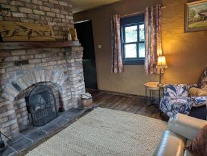 a living room with a brick fireplace and a couch at Riverside Cottage in Castledawson +18 photos