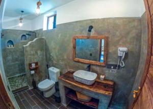 a bathroom with a sink and a toilet and a mirror at Ananda Beach Hotel in Paje