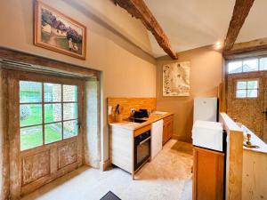 a kitchen with a sink and a refrigerator at Petite maison rurale in Anlhiac +10 photos