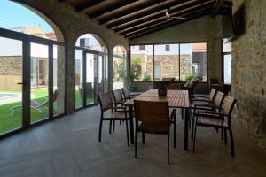 a dining room with tables and chairs and windows at Casa Rural La Botica de la Tía Paqui in Villanueva del Duque