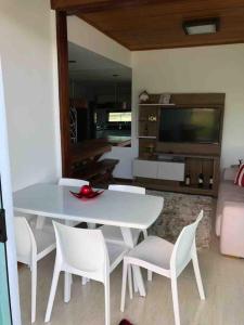 ein Esszimmer mit einem weißen Tisch und weißen Stühlen in der Unterkunft Bangalô monte castelo in Sairé