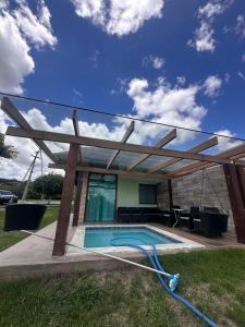 einen Pool mit einer hölzernen Pergola und einem Pool in der Unterkunft Bangalô monte castelo in Sairé + 23 Fotos