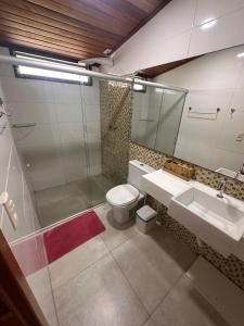 ein Badezimmer mit Toilette, Waschbecken und Spiegel in der Unterkunft Bangalô monte castelo in Sairé