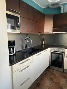 a kitchen with white cabinets and a black counter top at "Nitton" loistava sijainti Tammisaaren keskustassa in Ekenäs
