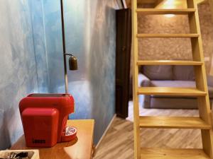 a red toaster sitting on a table next to a ladder at Poet's rooms in Taormina +48 photos
