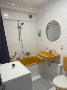 a bathroom with a yellow tub and a sink at Schwarzwald-Idylle in Schonach in Schonach +35 photos
