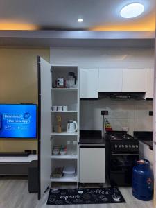 a kitchen with white cabinets and a tv in it at Mirenbe apartments in Nalakonge +13 photos