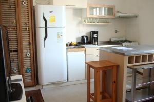 a kitchen with a white refrigerator and a table at La Casona, vistas al boulevard in La Plata