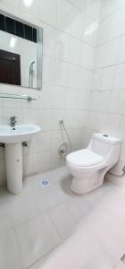 a white bathroom with a toilet and a sink at Salalah, Ronas صلالة- روناس in Salalah