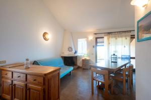Una sala de estar con una mesa y un comedor. en Elicriso, en Costa Paradiso