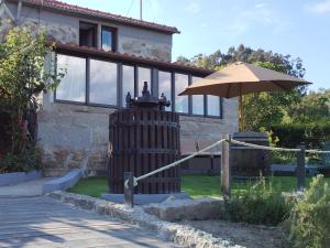 a house with an umbrella in front of it at Belo Encanto do Paiva in Castelo de Paiva