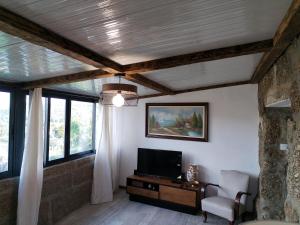 a living room with a tv and some windows at Belo Encanto do Paiva in Castelo de Paiva