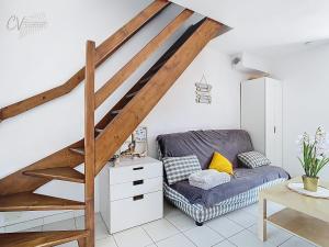 a living room with a couch and a staircase at Maison "Havre de Paix" dans résidence avec piscine in Vias