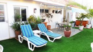 two chairs and a table on a patio with grass at Un petit coin de paradis à Ouakam-Mamelles in Dakar