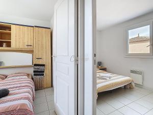 a small bedroom with a bed and a window at Maison "Havre de Paix" dans résidence avec piscine in Vias
