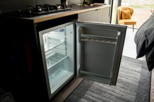 an empty refrigerator with its door open in a kitchen at Panoramahytte med utsikt mot Eggenipa in Egge
