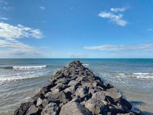 a pile of rocks in the ocean on the beach at Maison "Havre de Paix" dans résidence avec piscine in Vias