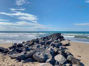 a pile of rocks on a beach next to the ocean at Maison "Havre de Paix" dans résidence avec piscine in Vias