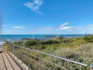 a walkway to the beach with the ocean in the background at Maison "Havre de Paix" dans résidence avec piscine in Vias