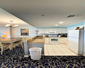 een keuken met een witte koelkast en een tafel bij Wyndham Ocean Walk Resort 2125 - Vacation in Comfort and luxury - 3BR Direct Oceanfront in Daytona Beach