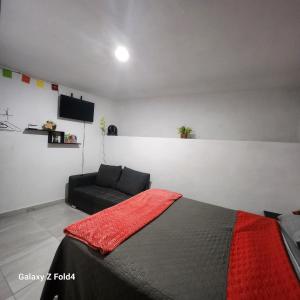 ein Schlafzimmer mit einem Bett und einer Couch in der Unterkunft Casa Linda Vista 2 in Cedro