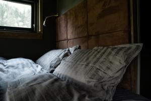 a bed with a pillow and a window in a room at Panoramahytte med utsikt mot Eggenipa in Egge