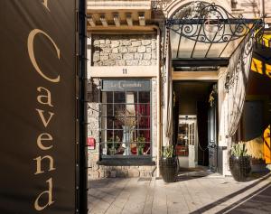 a facade of a building with potted plants on a sidewalk at Le Cavendish in Cannes