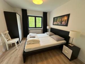 a bedroom with a bed and a chair in it at Villa Holgenbach - Penthouse- und Ferienwohnung im Nationalpark Eifel in Schleiden +65 photos