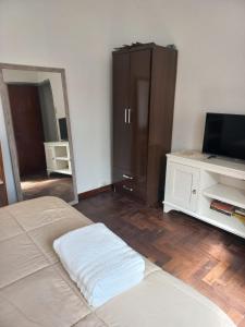 a bedroom with a bed and a tv and a dresser at PH La Plata Casco Urbano in La Plata