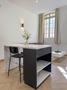 a desk with a vase of flowers on it in a room at T2 luxe 100m Port 2Toulon Clim Wifi fibre SmartTV in Toulon