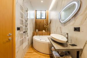 a bathroom with a tub and a sink and a mirror at Arbo Boutique Hotel in Durrës +50 photos