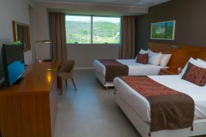 Un pat sau paturi într-o cameră la Orfeo Suites Hotel Sierras Chicas