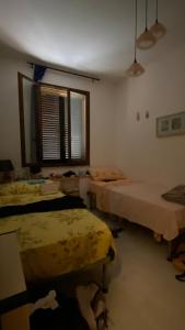 a room with several beds in a room with a window at La casina al mare in Grosseto