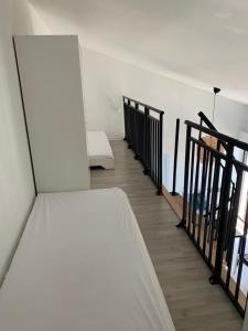 a white bed in a room with a staircase at Appartement quartier des Minimes avec piscine, parking, en bordure du port à La Rochelle in La Rochelle