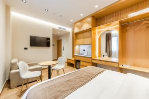 a hotel room with a bed and a table and chairs at Arbo Boutique Hotel in Durrës