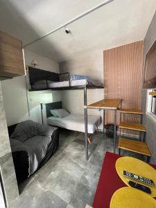 una stanza con due letti a castello e una scrivania di cozy Loft 6, air conditioning, WI-FI, TV, kitchen a Nova Iguaçu