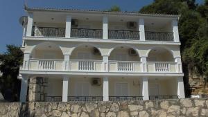 a large white building on top of a stone wall at Anemone Blue Seaside Apartments in Zakynthos Town