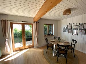 a dining room with a table and chairs and a window at Uferglück Plau - mit eigenem Seezugang in Plau am See