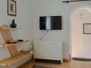 a living room with a flat screen tv on a wall at Hütterhof in Grundlsee