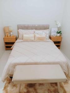 een slaapkamer met een groot wit bed en 2 nachtkastjes bij Langga Crib in Lapu Lapu City