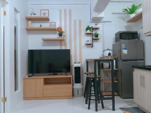 a living room with a television on a wooden entertainment center at Langga Crib in Lapu Lapu City