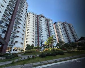 two tall apartment buildings with palm trees and bushes at Langga Crib in Lapu Lapu City