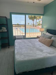 a bedroom with a bed with a view of the beach at Arvilla Resort in St Pete Beach +35 photos
