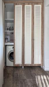a laundry room with a washing machine and wooden cabinets at Leos Apartments Apart3 in Side