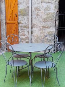 a metal table and two chairs with a table and a door at gite morvan in Lormes