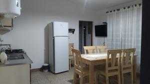 a kitchen with a refrigerator and a table and chairs at Las vasijas in Villa Amancay