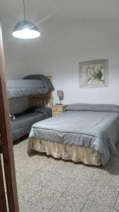 a bedroom with two beds and a lamp at Las vasijas in Villa Amancay