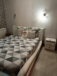 een slaapkamer met een zwart-wit geruit bed bij Corneguerre Grand Brassac in La Peyzie