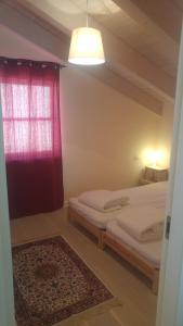 a bedroom with two beds and a red curtain at ליד המצוק in Mitzpe Ramon